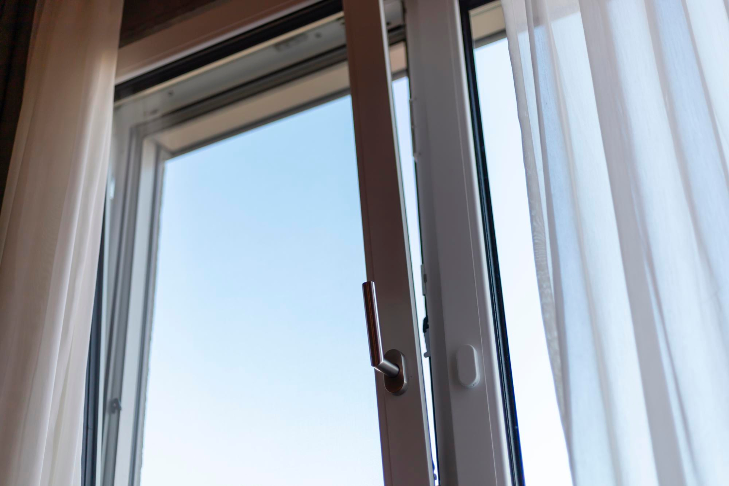 Une fenpetre est ouverte en oscillo-battant vers l'intérieur d'une maison